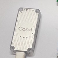 The Coral USB Accelerator: a small white metal stick with a USB-C cable.